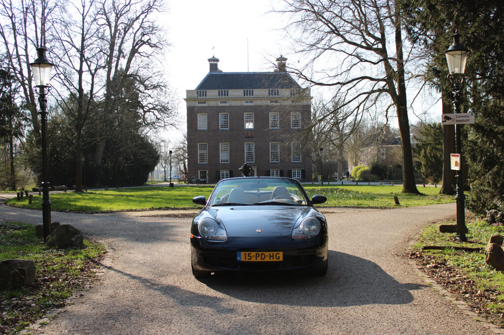Blauwe Porsche 911 Cabriolet met Nederlands kenteken voor historisch landhuis in Nederland