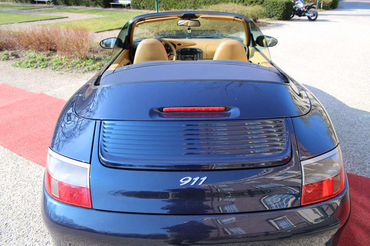 Porsche 911 Cabriolet in donkerblauw met beige leren interieur, achteraanzicht